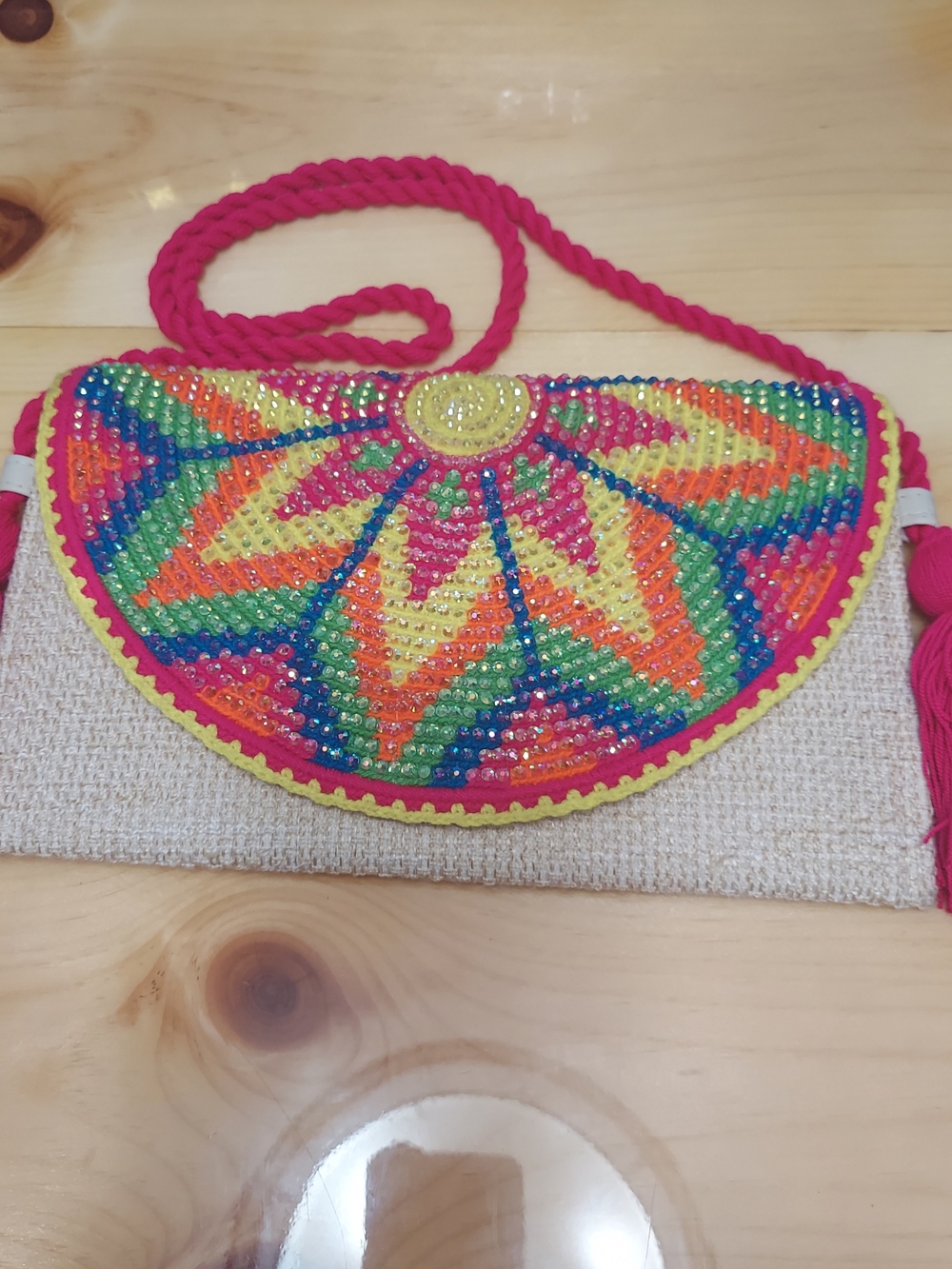 Handmade Wayuu-style jute clutch featuring a vibrant, multicolored beaded floral